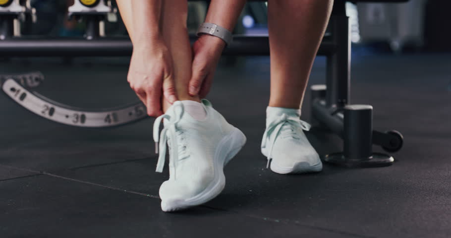 Fitness, hands and woman with ankle pain in studio from gym injury, muscle tension and inflammation. Athlete, person and fracture at wellness club from exercise mistake, foot accident or sprain