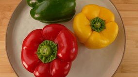 Fresh red, green and yellow bell peppers in a plate rotating top view.  - Powered by Shutterstock - Get 15% off with code: PIKWIZARD15