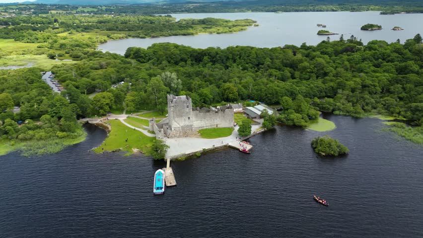 4K Aerial view of Ross Castle, capturing the historic stone walls, surrounding lakeshore, and lush green landscapes of Killarney National Park. Kerry_03