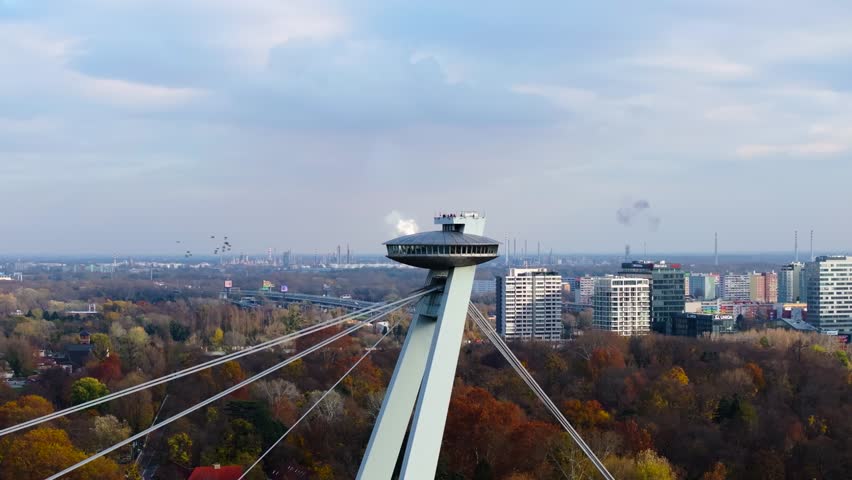 4K cinematic drone footage of the UFO Tower in Bratislava, showing the futuristic observation deck rising above the SNP Bridge with sweeping views of the Danube River and city skyline._14