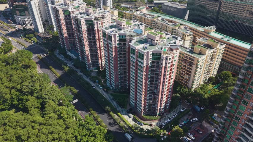 Aerial of a modern residential area in Shenzhen, China, showcasing high-rise apartment buildings and surrounding greenery. Ideal for real estate, urban development, and lifestyle footage. UHD.