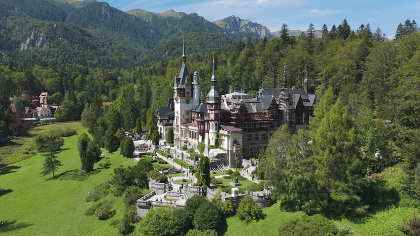 Orbiting Peleș Castle, highlighting its placement amid lush greenery with the Carpathian Mountains in the background.