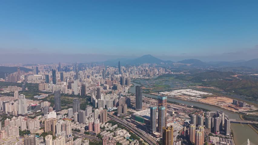 Aerial of Shenzhen city skyline in China, showcasing modern skyscrapers and the natural landscape along the Hong Kong border. Ideal for projects focused on urban development, cityscapes, real estate.