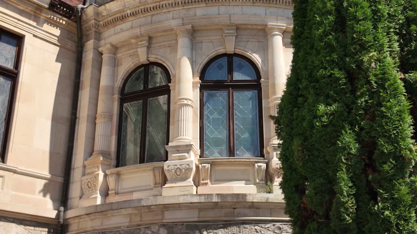 Tilt-up view capturing the detailed architecture of Peles Castle as the frame rises toward the clock tower.