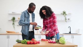 An African American couple prepares a meal together in a bright, modern kitchen, focusing on chopping vegetables. - Powered by Shutterstock - Get 15% off with code: PIKWIZARD15