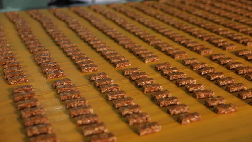 Chocolates move on a conveyor belt in a chocolate factory.