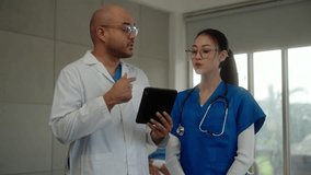 Young asian professional doctor man talking with physician woman with using tablet discussion patient report in hospital, medical team healthcare having conversation with colleague in modern building. - Powered by Shutterstock - Get 15% off with code: PIKWIZARD15