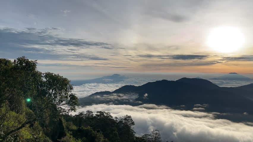 Stunning sunrise over mountain peaks with clouds below, capturing a serene and breathtaking natural landscape.