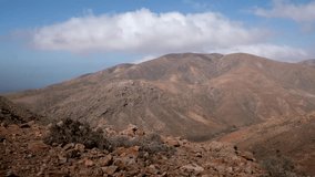 Scenic aerial landscape of arid desert mountains with low clouds hanging over the peaks. Dry geological terrain background with red soil. - Powered by Shutterstock - Get 15% off with code: PIKWIZARD15