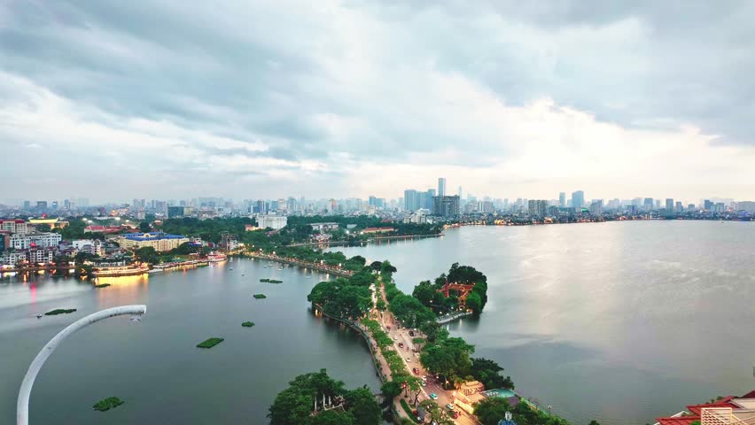 Timelapse of Hanoi city, Vietnam with road crossing the island lake with green tree lined street, temple located between small oasis.