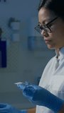 Vertical video of Female laboratory technician pipetting blood sample on the slide, preparing specimen for microscope examination, slow motion shot. Blood testing concept. - Powered by Shutterstock - Get 15% off with code: PIKWIZARD15