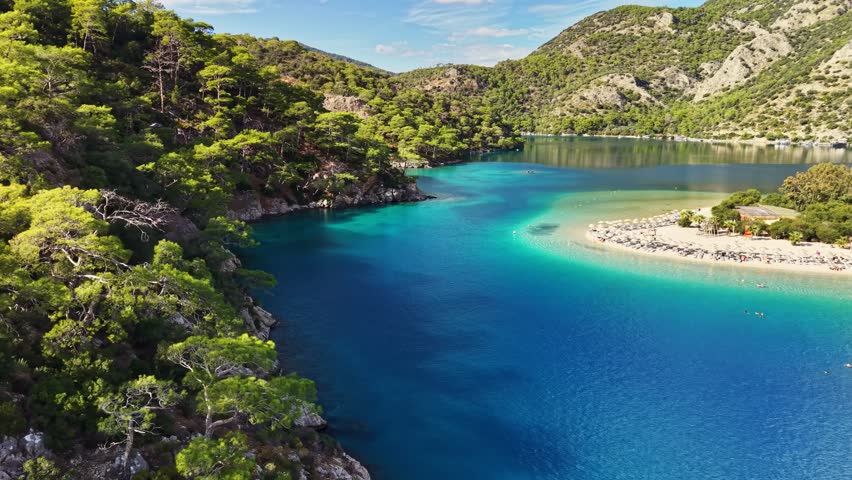 Stunning blue waters and peaceful beaches of Oludeniz in Turkey during sunny afternoon. Flying over blue lagoon in Oludeniz. Best travel destinations in Turkey, aerial shot