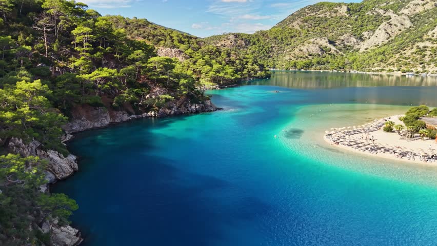 Stunning blue waters and peaceful beaches of Oludeniz in Turkey during sunny afternoon. Flying over blue lagoon in Oludeniz. Best travel destinations in Turkey, aerial shot