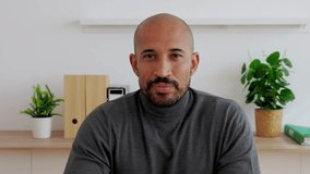 POV of happy handsome businessman sitting on table at home. Smiling headshot of young adult man looking at camera from office workplace  - Powered by Shutterstock - Get 15% off with code: PIKWIZARD15