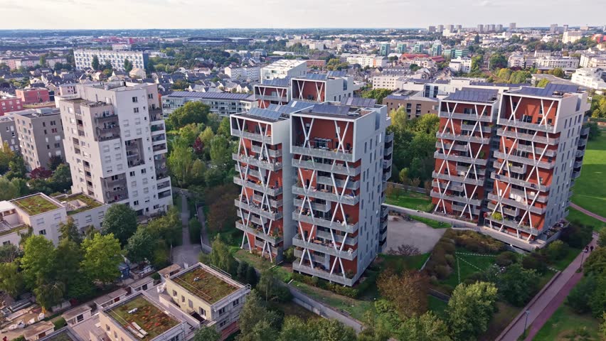 Aerial drone view of contemporary residential architecture in the La Courrouze district of Rennes, France. Modern apartment buildings feature unique facades and green surroundings