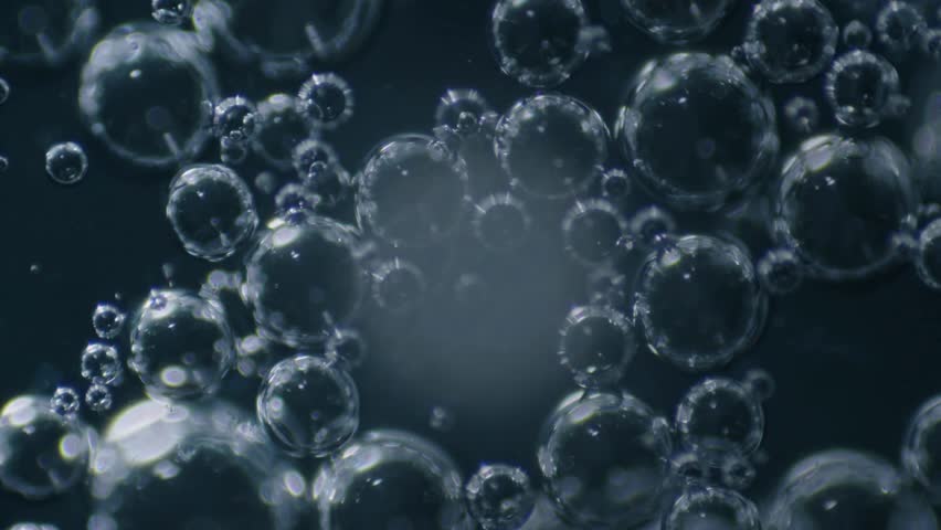 Extreme macro view of a saliva droplet with air bubbles rotating on a specimen slide, showcasing detailed biological texture and microscopic movement.