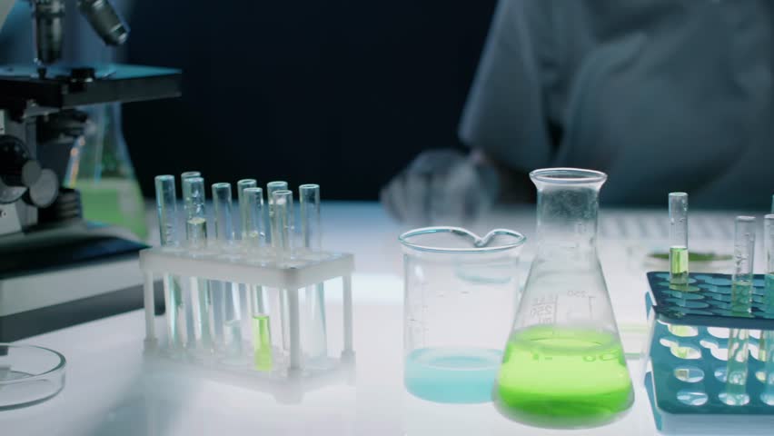 Close-up of rows of vials and test tube racks on a lab worktop, highlighting scientific research and laboratory organization.