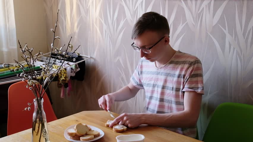 young man in the kitchen is preparing food for himself
