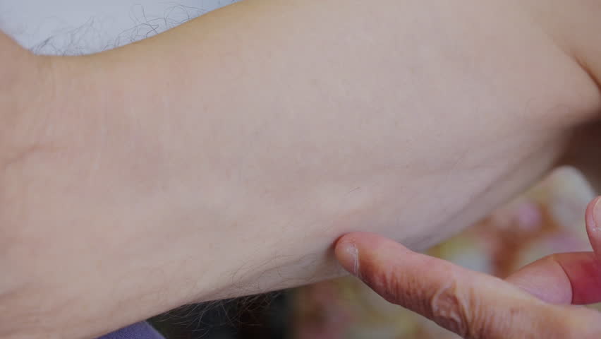 Close-up view of a person checking the blood flow and heartbeat pulsation on an older man