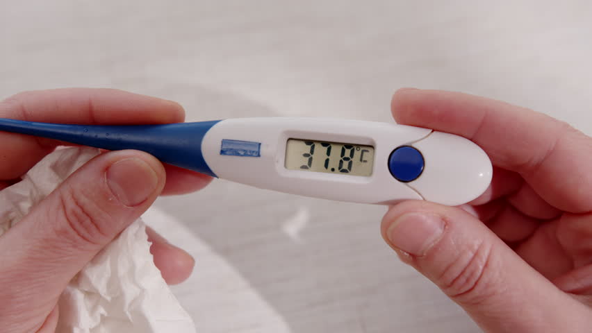 Digital medical thermometer in hand showing elevated body temperature of 37.8 degrees Celsius on electronic display close-up