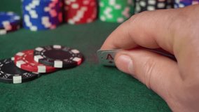 A hand grips an ace card while playing poker on a green felt table. Surrounding colorful chips indicate a competitive atmosphere, capturing the excitement of the game. - Powered by Shutterstock - Get 15% off with code: PIKWIZARD15