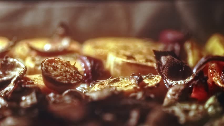 Fresh assorted veggies roast on a tray inside a heated oven, becoming golden, tender, and aromatic as they cook under steady, even heat.