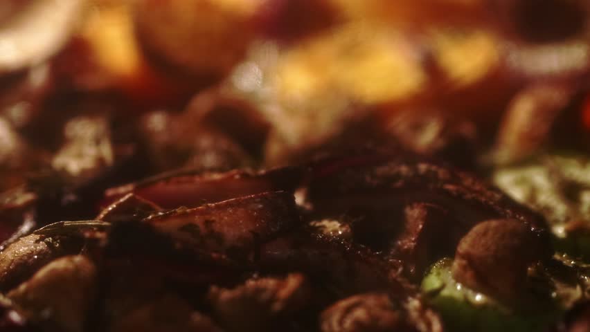 Colorful vegetables bake in the oven, their edges caramelizing while steam lifts from the warming tray, showing a close-up of the roasting process.
