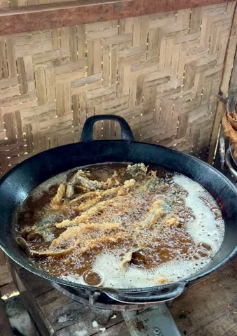someone is frying some catfish in a frying pan with cooking oil that looks very hot