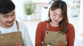 Small business cafe entrepreneur couple enjoying good performance, happy together while working on business plan using laptop technology, barista man and employee teamwork in cozy coffee shop startup - Powered by Shutterstock - Get 15% off with code: PIKWIZARD15