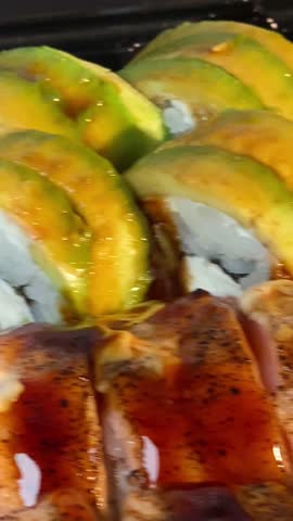 Close-up of sushi rolls with chopsticks on plate