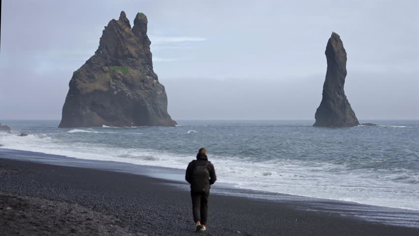 Person on Coast with Volcanic Rocks