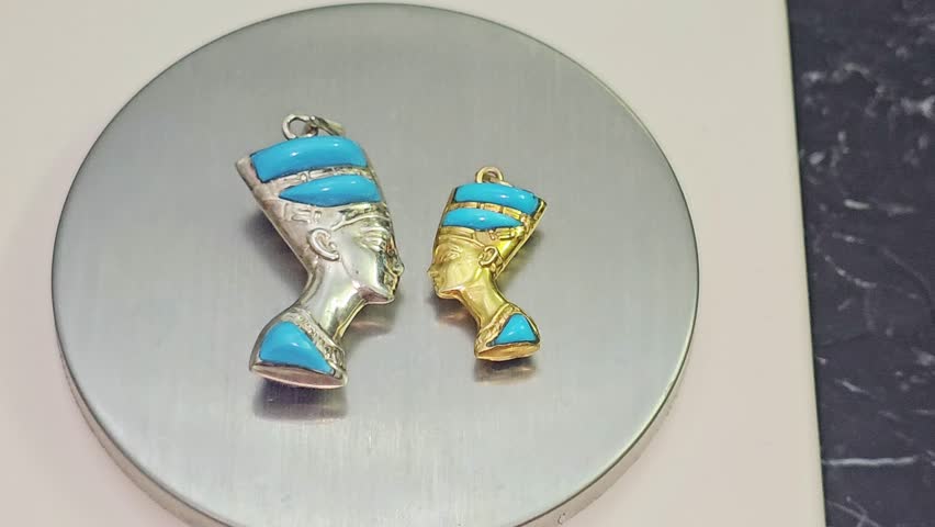 Two pendants of gold and silver featuring bust of queen Nefertiti the wife of the Pharaoh Akhenaten, during the 18th Dynasty, Her name means (the beautiful one has arrived), precious metal pendants
