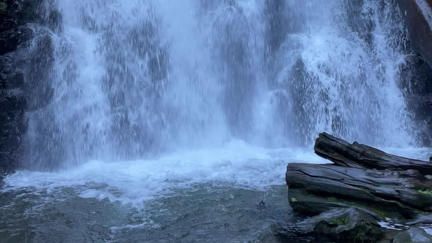 Beautiful cascading waterfall flowing over rocky cliffs, surrounded by lush nature and misty spray in a peaceful scenic landscape