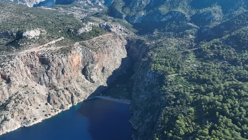 Aerial view of natural landscapes featuring mountains, forests, and open terrain.