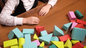 Little girls hands arranging colorful foam blocks on wooden table, building simple structure during quiet playtime, early learning scene for preschool materials, toy brands and parenting blogs - Powered by Shutterstock - Get 15% off with code: PIKWIZARD15