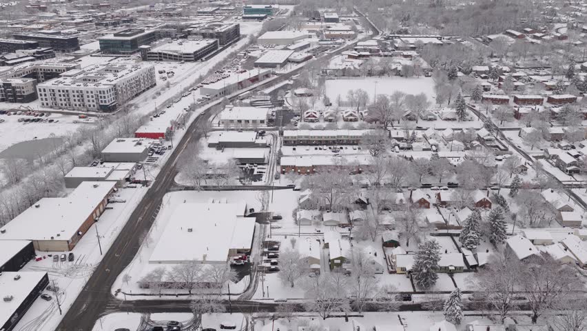 Upper class American suburban suburb near Columbus, Ohio in middle class neighborhood with homes, townhouses, houses, streets, and roads during a wintry and snowy winter storm with cold snow and ice