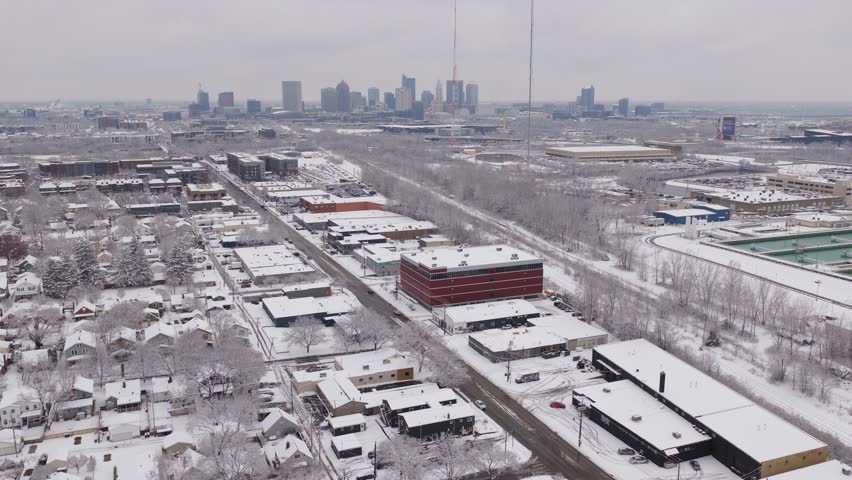 Columbus, Ohio downtown city near Franklinton Peninsula and Scioto Mile river park during an early wintry winter snowstorm with buildings, roads, and offices covered in ice, snow, and cold environment