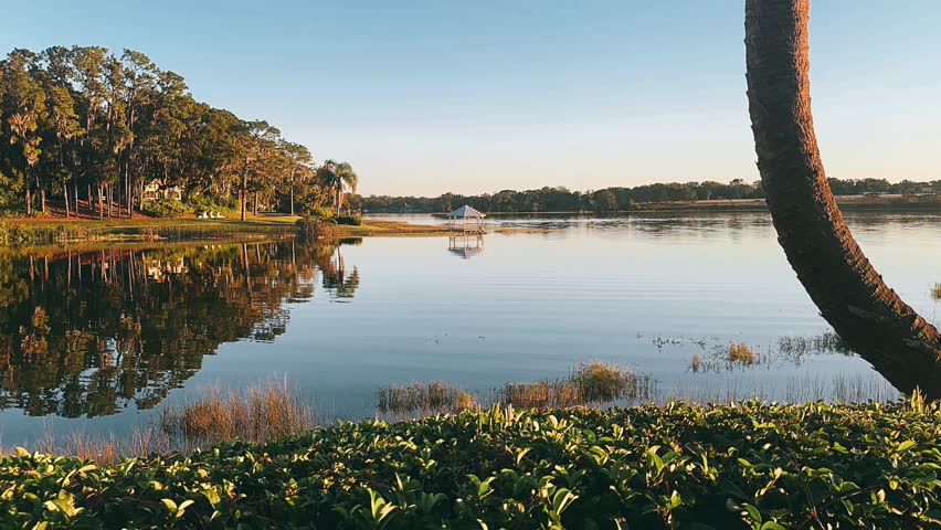 peaceful view of a calm tranquil lake reflecting soft natural light across the still quiet water on a gentle day