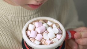 Warm cocoa topped with soft marshmallows in charming snowman mug creates cozy holiday feeling. Child holds mug in his hands, capturing sweet festive atmosphere and anticipation of Christmas season. - Powered by Shutterstock - Get 15% off with code: PIKWIZARD15