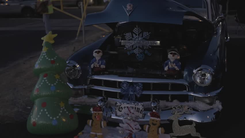 This video shows a vintage, classing 1950s Cadillac car, decorated in festive Christmas, holiday decor.