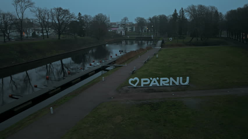 Peaceful dusk at Parnu park river, Evening aerial view of Parnu park along river under overcast sky