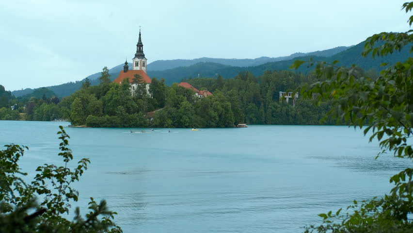 Bled island with assumption of mary pilgrimage church on lake bled, slovenia. Tranquil lake bled surrounds bled island, featuring the iconic assumption of mary pilgrimage church, amidst lush greenery