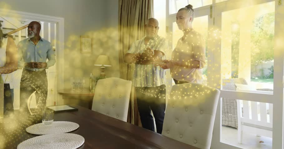 Guests at table, gift bag appearing, woman reaching, golden glow sweeping across group, events. Dining, family, home, daylight, patio, celebration, conversation