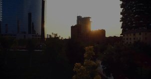 Sun emerging behind central midrise casting glare, glinting glass, revealing plaza, graphs sweeping. Goldenhour, skyline, reflections, urban, park, architecture, skyscraper - Powered by Shutterstock - Get 15% off with code: PIKWIZARD15