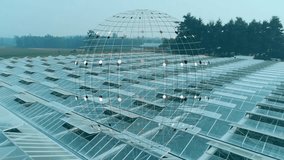 Aerial camera starting glide, wireframe globe rotating and pulsing over greenhouses showing network. Agriculture, roofs, glass, farmland, rural, trees, overlay - Powered by Shutterstock - Get 15% off with code: PIKWIZARD15