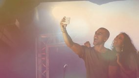 Center man raising smartphone taking selfie, music band leaning, checking drumsticks under lights. Stage, ensemble, spotlight, lensflare, bokeh, concert, friends - Powered by Shutterstock - Get 15% off with code: PIKWIZARD15