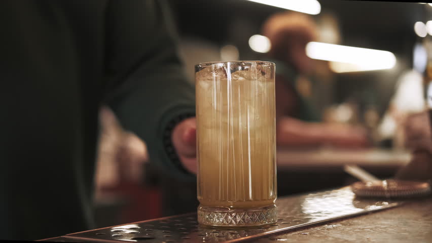Cold drink. Served cocktail. Bartender hand garnishing tall glass of juice ice cubes with aromatic sprig green mint dried orange slice. - Powered by Shutterstock - Get 15% off with code: PIKWIZARD15
