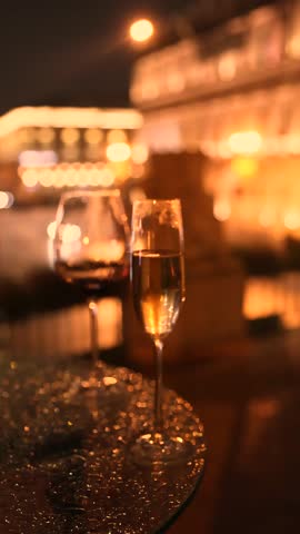 Closeup of two glasses one for champagne and one for wine with sparkling reflections warm evening light and cozy cinematic lamp atmosphere capturing half full drinks and romantic mood