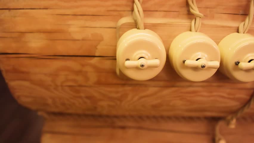 Decorative vintage light switches on wooden wall with retro interior details