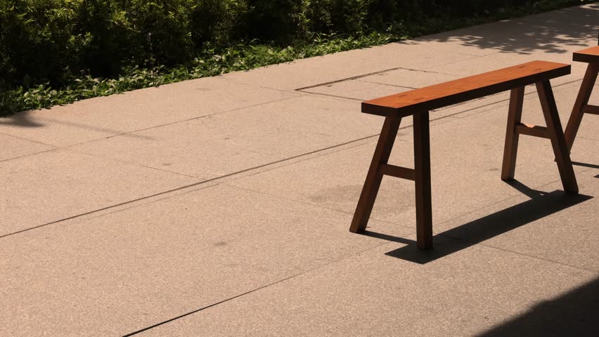 Wooden park benches on city street under sunlight urban outdoor scene
